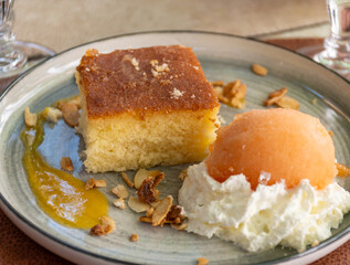 Piece of homemade orange cake with melon ice cream and whipped cream
