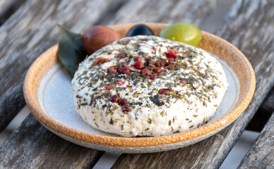 French fresh white soft goat cheeses with topping made with herbs, paprika, indian curry,  chives and dried tomatoes