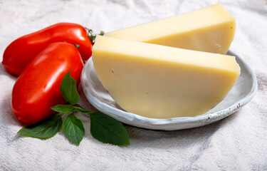 Italian cheese, Provolone dolce cow cheese from Cremona served with olive bread and tomatoes close up
