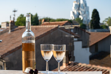 French cold rose dry wine from Provence in two glasses in sunny day with view on old roofs of Arles...