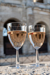 French rose dry wine from Provence in two glasses in sunny day with view on old streets of Arles town.