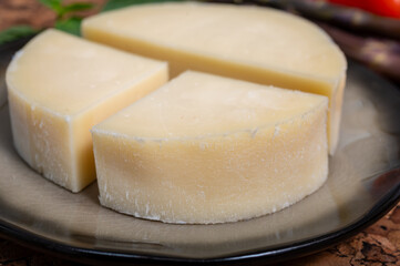 Italian cheese, Provolone dolce cow cheese from Cremona served with olive bread and tomatoes close up