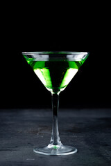 Alcoholic green cocktail apple martini with olives in a glass.