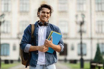 College Scholarships. Outdoor portrait of cheerful male student with backpack and workbooks