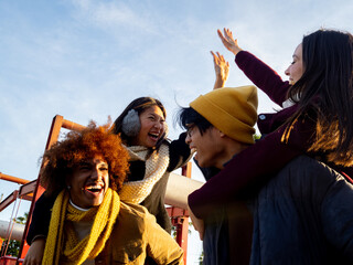 Group of multi-ethnic friends in winter clothes having a good time in a city. Concept of community, friendship, winter