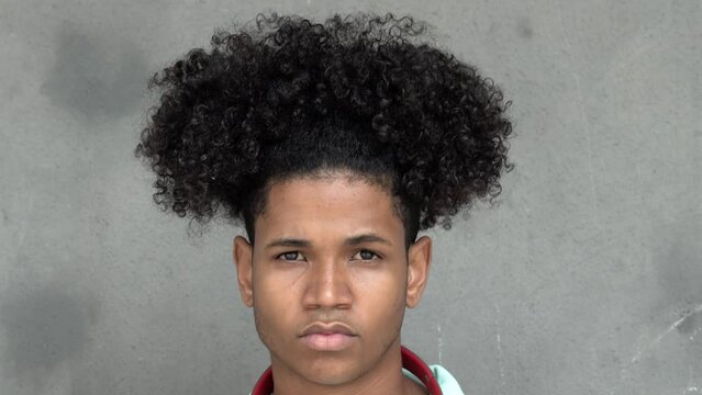 Portrait of a teenager boy with afro hair looking seriously at camera