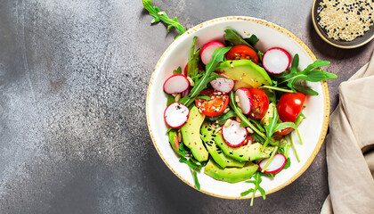 Diet menu. Healthy salad of fresh vegetables - tomatoes, avocado, arugula, radish and seeds on a bowl. Vegan food. Flat lay. Banner. Top view