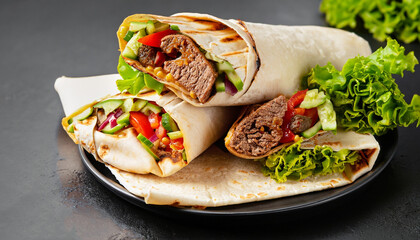 Burritos wraps with beef and vegetables on black background. Beef burrito, Mexican food.