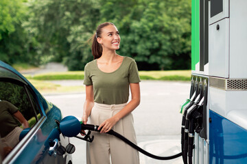 Happy Young Woman Refueling Car At Modern Gas Station Outdoor - obrazy, fototapety, plakaty