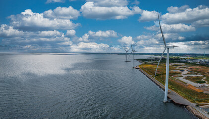 Aerial view of the wind turbines. Green ecological power energy generation. Wind farm eco field. Offshore and onshore windmill farm green energy at sea. Offshore wind turbines on the coast of Copenhag