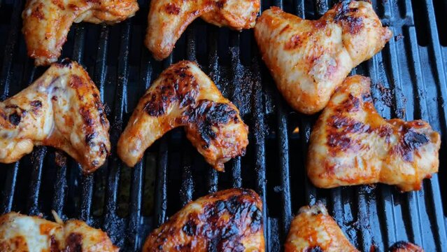 Cooking roast juicy chicken wings on the barbecue grill.