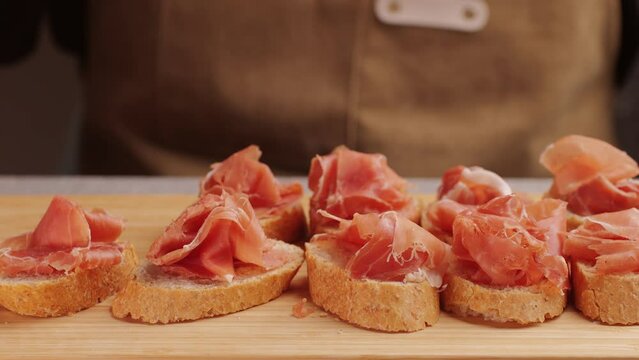 Jamon iberico tapas close up, chef cooking the best spanish ham pork tapas, cafe with traditional food.