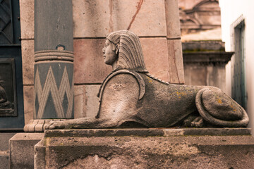 figure statue of a sphinx in an outdoor cemetery park with natural light