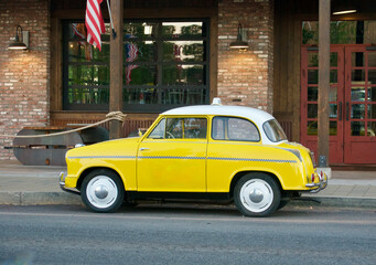 cute little vintage taxicab parked at the curb for the next fare
