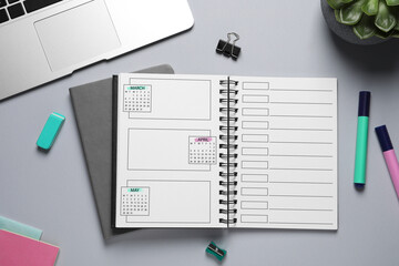 Self organization with bullet journal. Notebook with calendar and empty planning lists near stationery on grey table, flat lay - obrazy, fototapety, plakaty