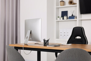 Stylish director's workspace with computer and stationery on desk in office. Interior design