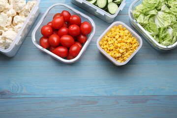 Plastic and glass containers with different fresh products on light blue wooden table, flat lay. Space for text
