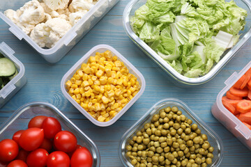 Plastic and glass containers with different fresh products on light blue wooden table, flat lay