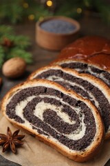 Slices of poppy seed roll and anise star on table, closeup with space for text. Tasty cake