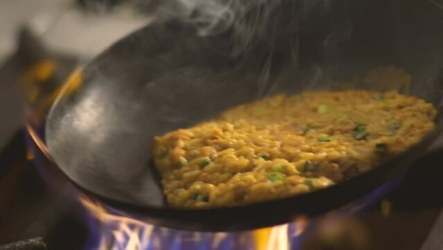 Cooking Peruvian tacu tacu in wok, traditional dish of Peruvian food, high heat, delicious