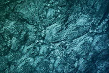 Blue green gray teal aqua turquoise rough mountain surface. Close-up. Toned stone rock mineral...