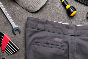 Work pants and tools on concrete.	

