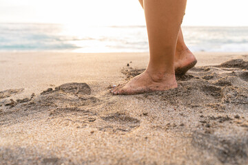 close-up of an unrecognizable woman's feet in the sand on the beach 