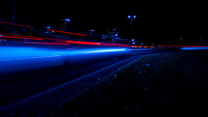 Fototapeta na wymiar Lights of cars at night. Street line lights. Night highway city. Long exposure photograph night road. Colored bands of red light trails on the road. Background wallpaper defocused photo. 