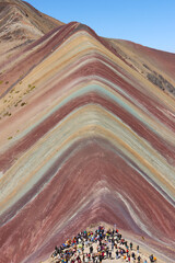 A vertical view of the rainbow mountain with tourists in Cusco, Peru