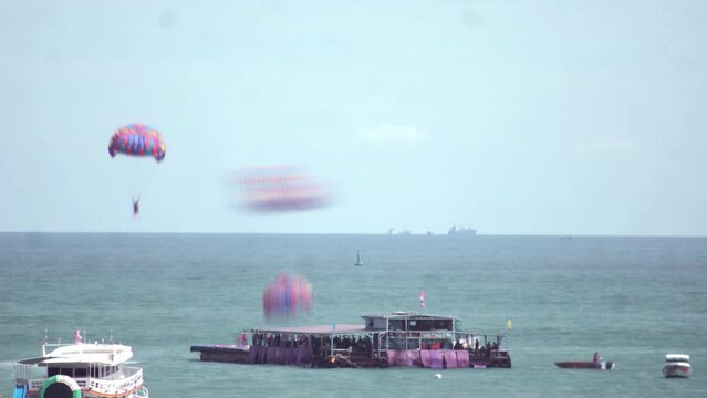 Time-lapse footage of people parasailing above the sea.