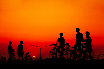 Fototapeta na wymiar Young people riding bicycles watching the sunset
