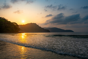 Summer holiday concept. Natural sea waves on the beach and sea water in summer with soft sunset rays. Evening time.