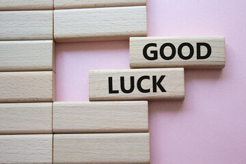 Good luck symbol. Wooden blocks with words Good luck. Beautiful pink background. Business and Good...