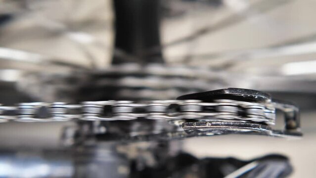 The chain runs through the rear derailleur tensioner roller on the mountain bike. View from above. Workshop bike repair and diagnosis. Close-up