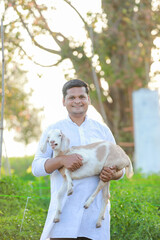Happy Indian farmer, holding indian Goat