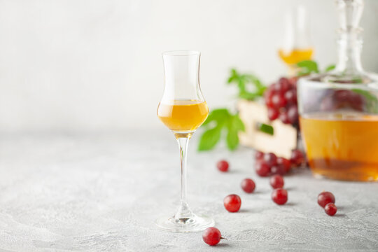 Grape vodka. Strong alcoholic drink in glasses on the table. Fresh grapes