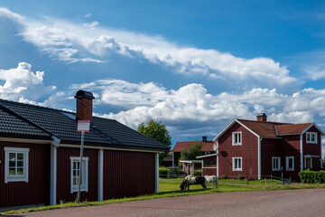 Nusnas, Sweden Wooden residential houses and horses grazing.