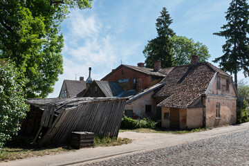 Street with old dilapidated house in Latvian Kuldīga Old Town