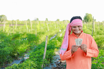 Happy Indian farmer, farmer holding indian rupees in hands, smart farming