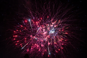 Holiday fireworks explode in the night sky. Selective focus.