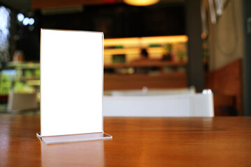 Mock up Menu frame standing on wood table in Bar restaurant cafe. space for text.