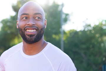 Happy biracial male basketball player wearing white tshirt at basketball court