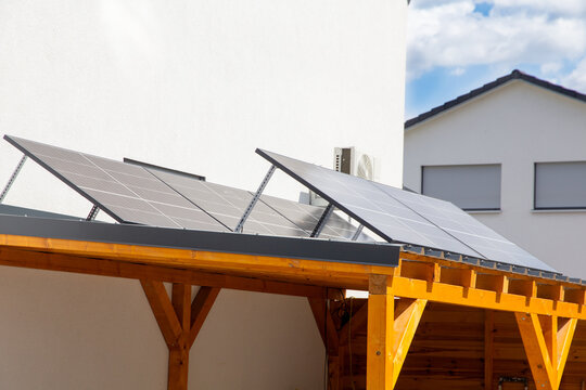 Holzcarport mit Solaranlage an einem Wohnhaus