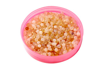 White and orange silica gel granules on pink dish isolated on white background. Desiccant to absorb any moisture.