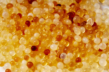 Close up of White and orange silica gel granules. Desiccant to absorb any moisture. bubble background.
