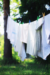 Dry clothes outside. Clothes on a rope. Clothespins on a clothesline in summer.