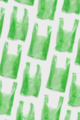 Top view pattern from Green plastic bags. Single-use polythene packet, Eco trend to reduce disposable plastics, Biodegradable packaging waste, creative photo pattern, vertical design background
