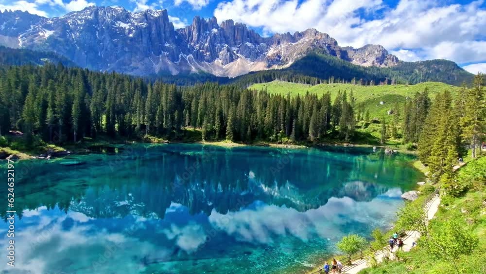 Wall mural idyllic nature scenery- trasparent mountain lake carezza surrounded by dolomites rocks- one of the m