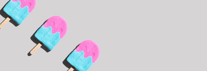 Pink and blue popsicles with shadow - flat lay