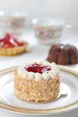 Blurred desserts in the background with a sharp focus on a jam cake 